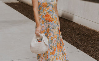Full body front view of female model wearing a floral midi dress and cream block heels