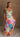 Blonde female model is wearing a pleated multi-color floral maxi dress