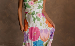 Blonde female model is wearing a pleated multi-color floral maxi dress