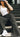 Lizard Thicket model is sitting on stairs, wearing black jeans and white tank top.
