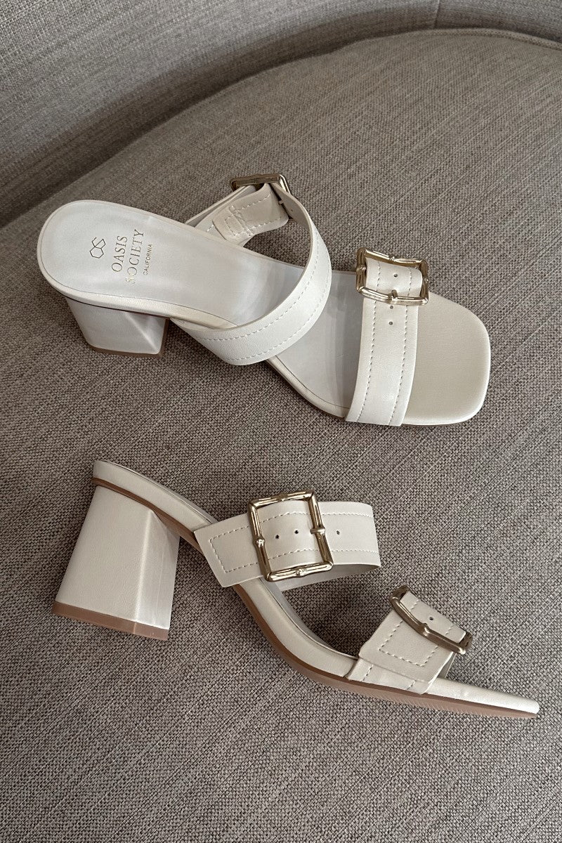 Side and top view of the Havana Beige Heeled Sandals that feature beige faux-leather material, two straps with adjustable gold buckles, square toes, and 2.5" block heels.
