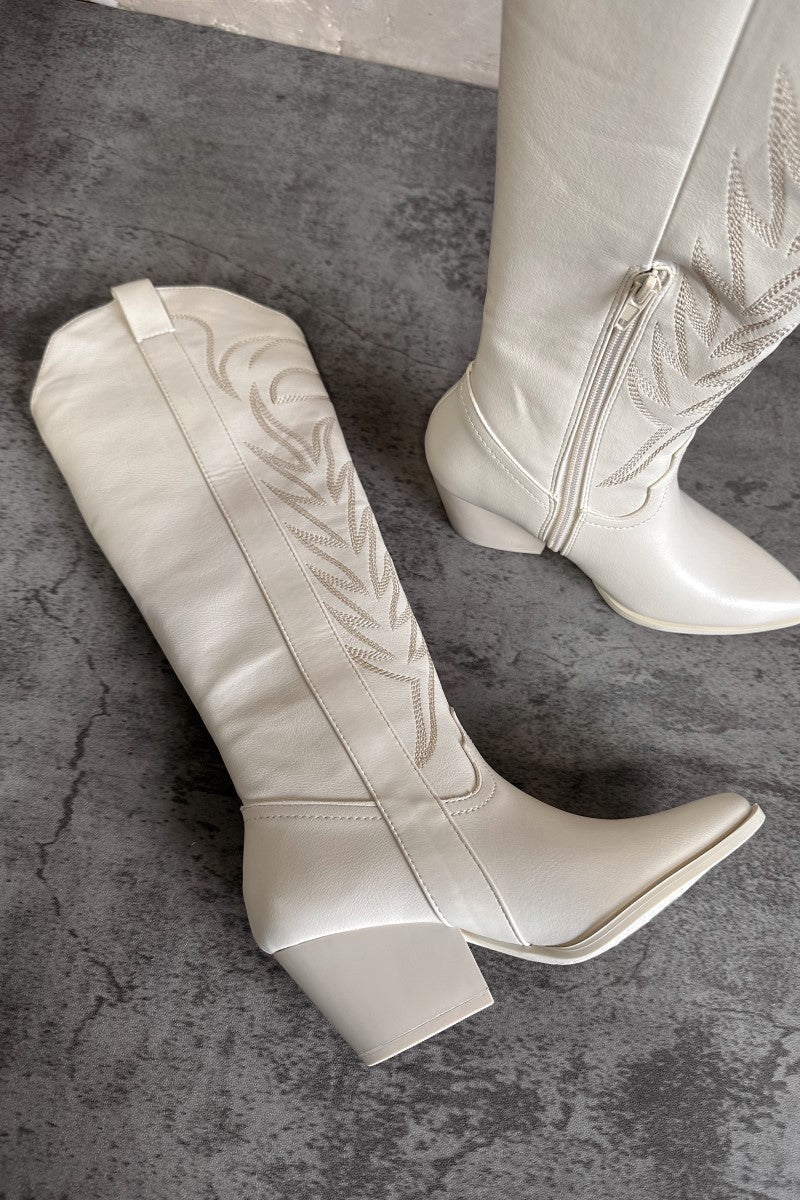 Aerial view of the Sierra Cream Western Boots that feature cream faux-leather with monochromatic western stitching, inner zipper closures, pointed toes, and 2.5" cream heels.