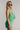 Side view of female model wearing the Jade Green Criss-Cross Back Tank which features Green Lightweight Fabric, Square Neckline, Overlap Back Details and Thick Straps