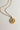 Image shows close-up of the Celeste Gold Star Medallion Necklace against a white background. Necklace has gold chain with circle medallion which has an 8 point star in the center.