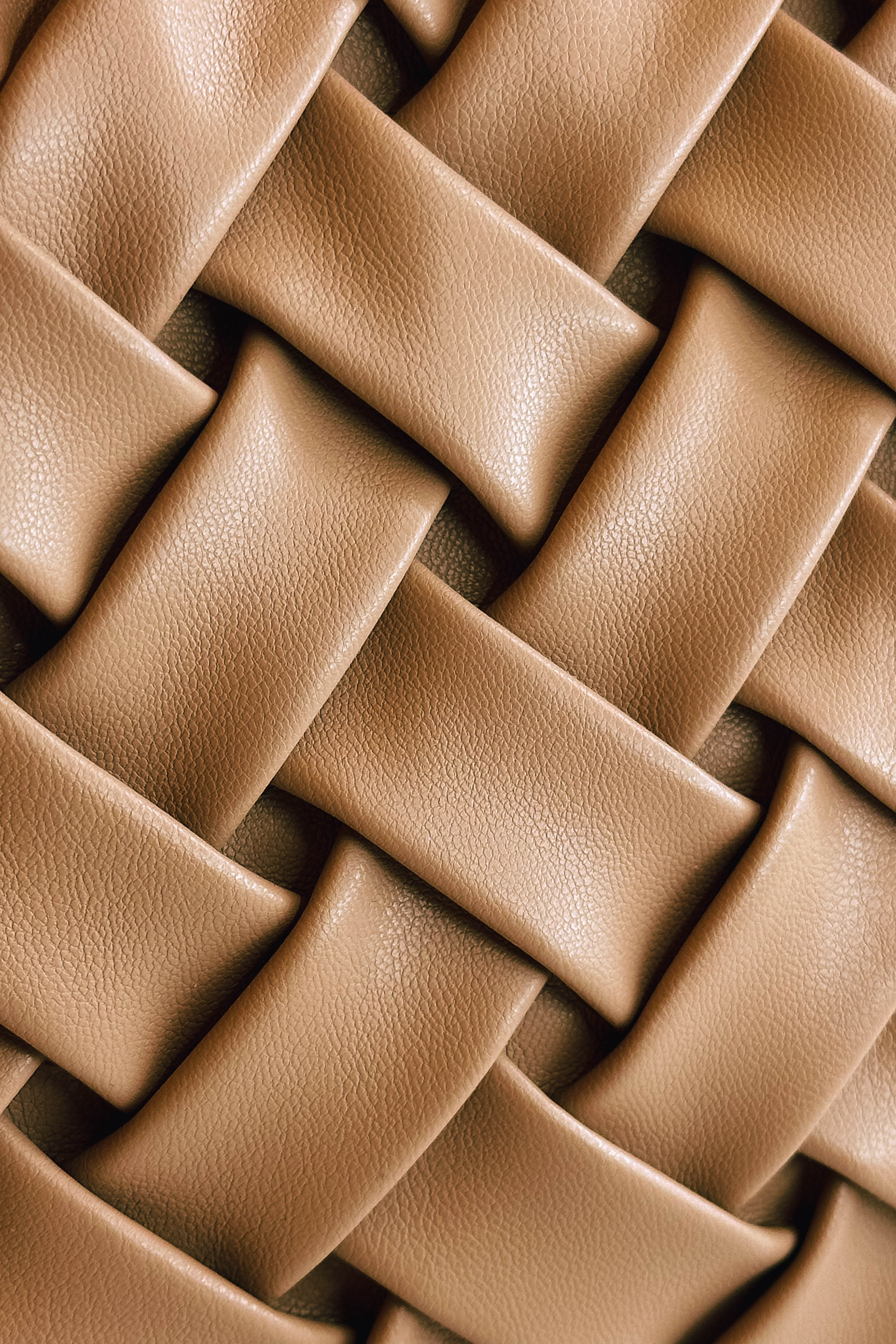 Close up view of the Jessica Taupe Woven Clutch which features taupe leather fabric, woven design, wooden clasp closure and removable gold chain strap.