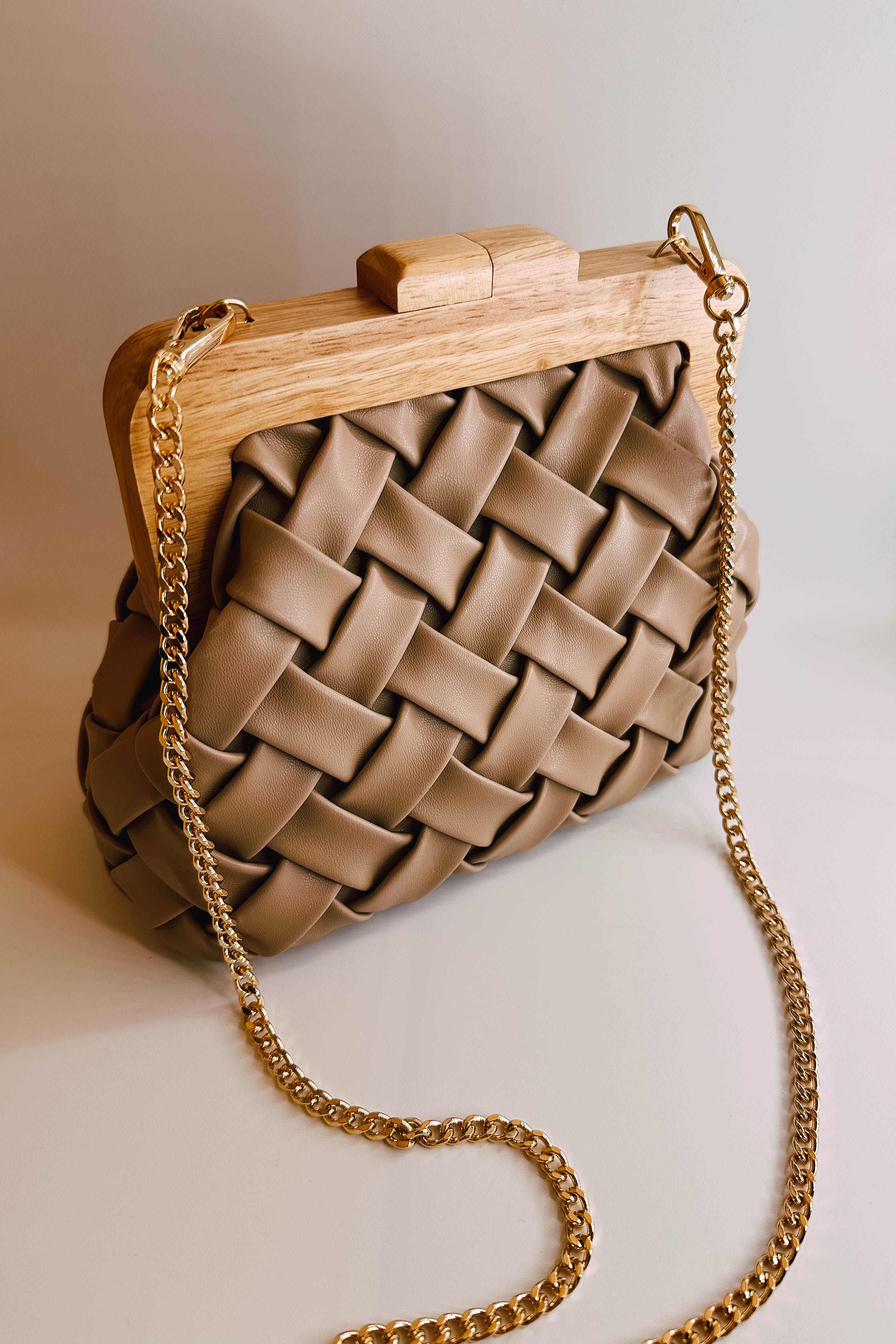 Ariel view of the Jessica Taupe Woven Clutch which features taupe leather fabric, woven design, wooden clasp closure and removable gold chain strap.