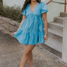 Full body view of female model wearing the  Stephanie Light Blue Short Puff Sleeve Mini Dress which features light blue light weight fabric, mini length, flared skirt, plunge neckline, short puff sleeves, tie closure in the back and monochrome side zipper with hook closure.