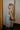 Side view of model wearing the blue colored Eleanor Sleeveless Button Front Mini Dress that has cotton fabric, a button-up front with silver buttons, buttoned chest pockets, a collared neckline, and a racerback cut.