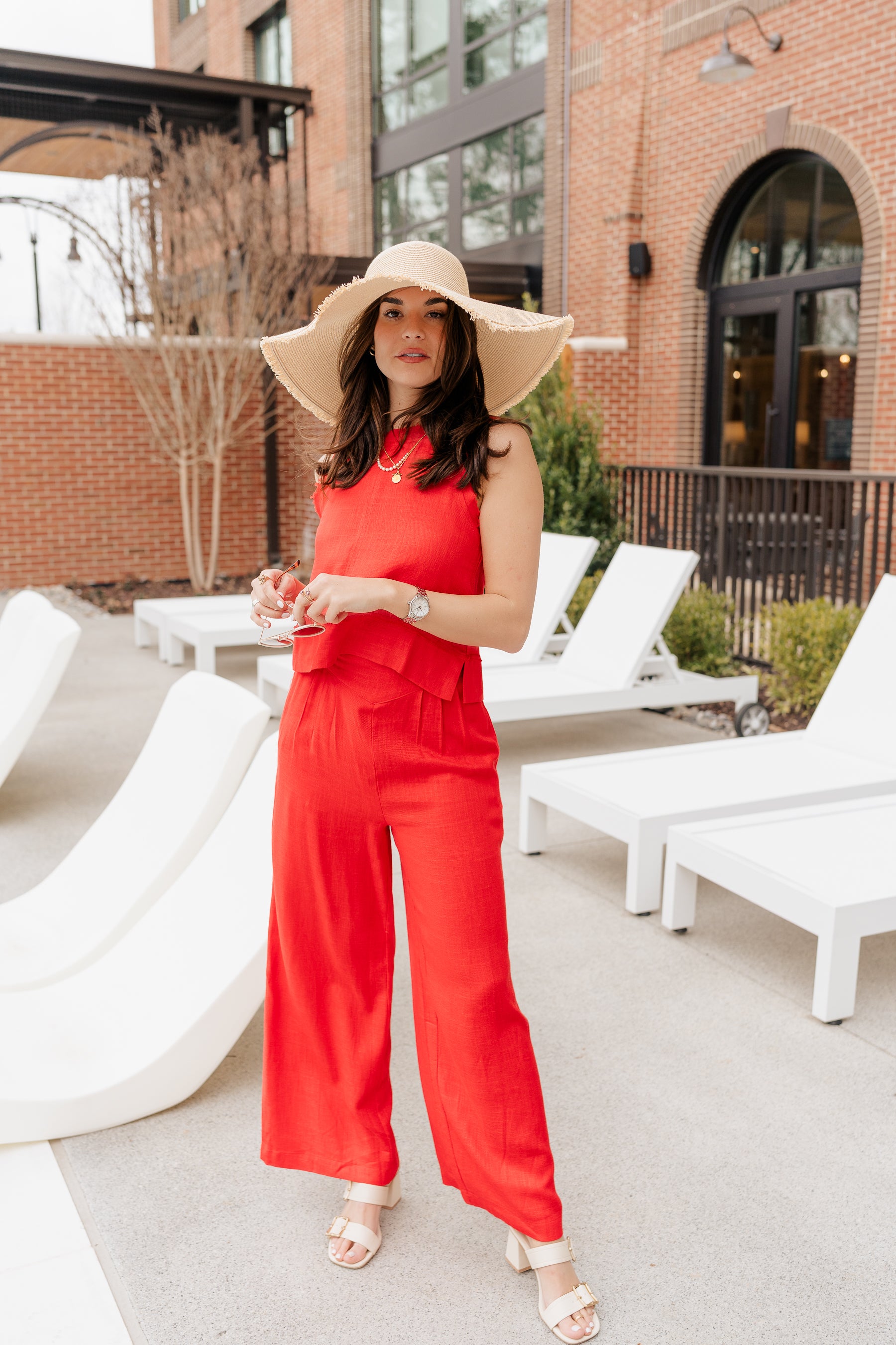 Full body front view of model wearing the Vada Red Wide Leg Pants that feature red woven fabric, side pockets, an elastic waistband, and flowy wide legs.