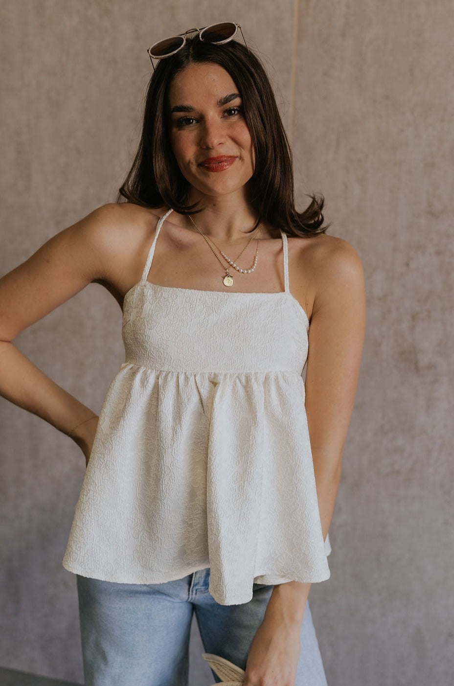 Front view of female model wearing the Sydney Cream Floral Sleeveless Tank which features Cream Floral Fabric Design, Square Neckline, Adjustable Tie Straps and Open Back Design.