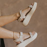 Right side view of female model wearing the Debra Sandal in Ivory Suede which features ivory suede and white rattan fabric, white platform sole, rubber outsole and adjustable velcro straps