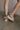 Back view of female model wearing the Chapmin Sport Sandal which features slip-on style, slingback design, round open toe, natural suede toe strap, triple-stacked platform sole, espadrille detailing, clear midsole, tread outsole, oversized ribbon laces, self-tie slingback strap