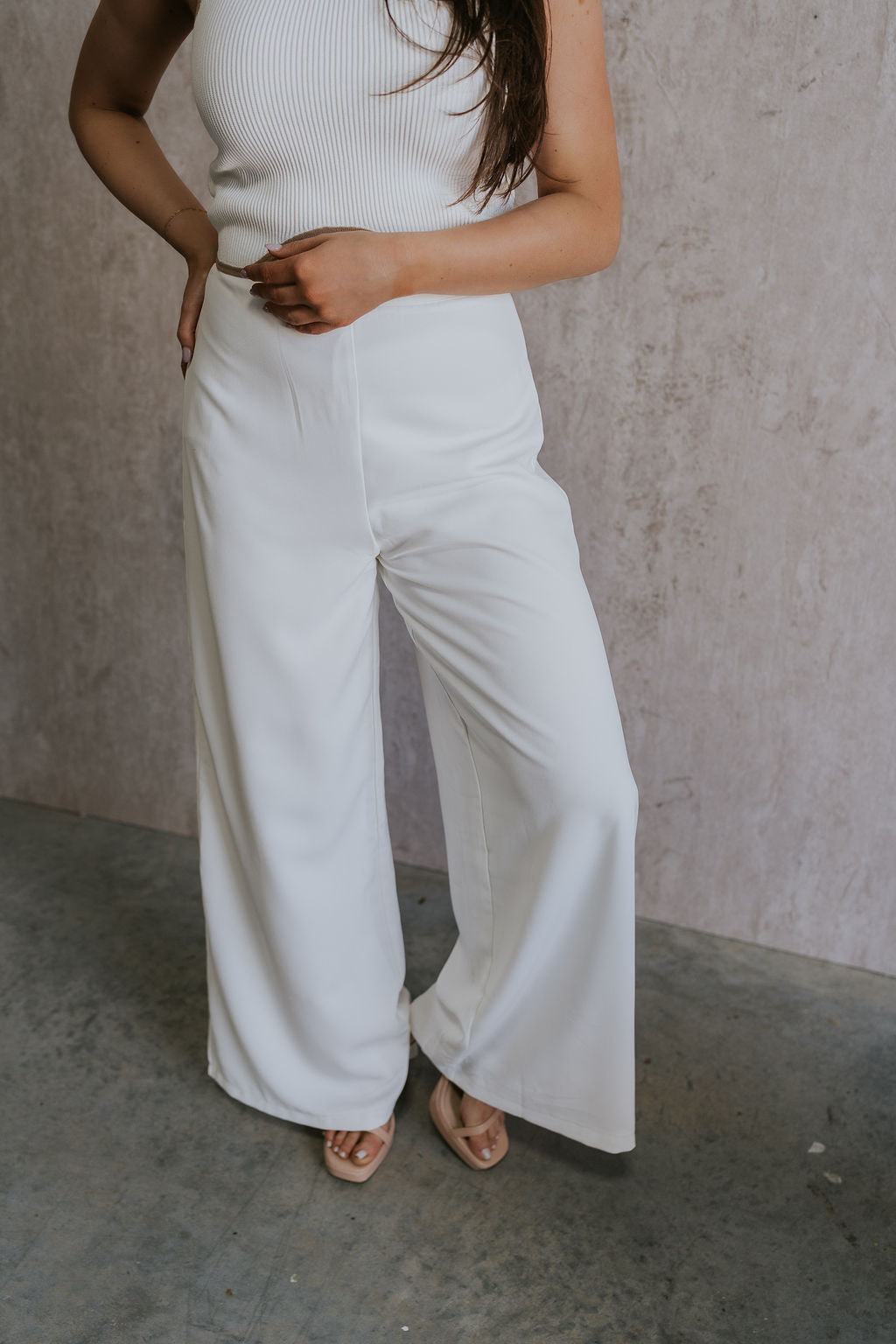 Front view of female model wearing the Sloane White Wide Leg Pants which features White Lightweight Fabric, Wide Leg Pants, Side Zipper with Hook Closure and White Lining