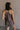 Back view of female model wearing the Vera Washed Black Sleeveless Romper which features Washed Black Cotton Fabric, Two Side Pockets , V-Neckline, Sleeveless and Adjustable Straps