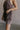 Close up side view of female model wearing the Vera Washed Black Sleeveless Romper which features Washed Black Cotton Fabric, Two Side Pockets , V-Neckline, Sleeveless and Adjustable Straps