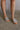 Front view of female model wearing the Baxter Sandal in Silver which features Silver Skinny Straps with Wooven Details,  Leather Upper, Padded Insole and Slip-On Style