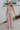 Full body view of female model wearing the Aleah Mauve Pink Sleeveless Jumpsuit which features Mauve Pink Lightweight Fabric, Wide Leg Pants, Upper Ruched Detail, Two Side Pockets, Scooped Neckline, Adjustable Straps and Open Back with Tie Closure and Zipper