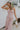 Front view of female model wearing the Aleah Mauve Pink Sleeveless Jumpsuit which features Mauve Pink Lightweight Fabric, Wide Leg Pants, Upper Ruched Detail, Two Side Pockets, Scooped Neckline, Adjustable Straps and Open Back with Tie Closure and Zipper