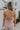 Back view of female model wearing the Aleah Mauve Pink Sleeveless Jumpsuit which features Mauve Pink Lightweight Fabric, Wide Leg Pants, Upper Ruched Detail, Two Side Pockets, Scooped Neckline, Adjustable Straps and Open Back with Tie Closure and Zipper