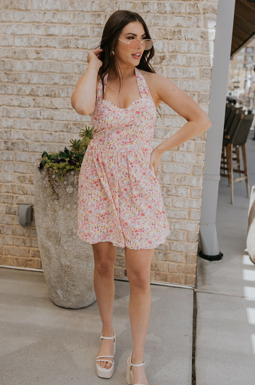 FUll body view of female model wearing the Sara Pink Floral Halter Mini Dress which features Pink Multi Floral Pattern, Mini Length, Corset Upper Detail, Sweetheart Neckline and Halter Neckline with Tie closure