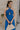 Front view of female model wearing the Juliette Blue Halter Tie Pleated Jumpsuit which features Blue Lightweight Fabric, Pleated Wide Pant Legs, Front Key Hole Design, Halter Neckline Tie Closure and Open Back