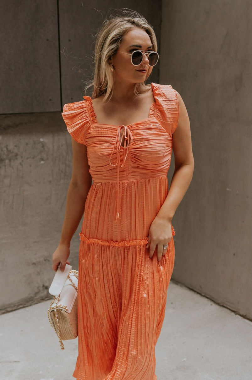 Front view of female model wearing the Maren Peach Key Hole Midi Dress which features Peach Crinkle Fabric, Midi Length, Peach Lining, Square Neckline with Key Hole Tie Closure, Ruffle Straps andTier Ruffle Skirt Detail