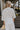Back view of female model wearing the Rebecca Ivory Linen Top which features vory Linen Fabric, Half Sleeves and Collared Neckline with V-Cutout