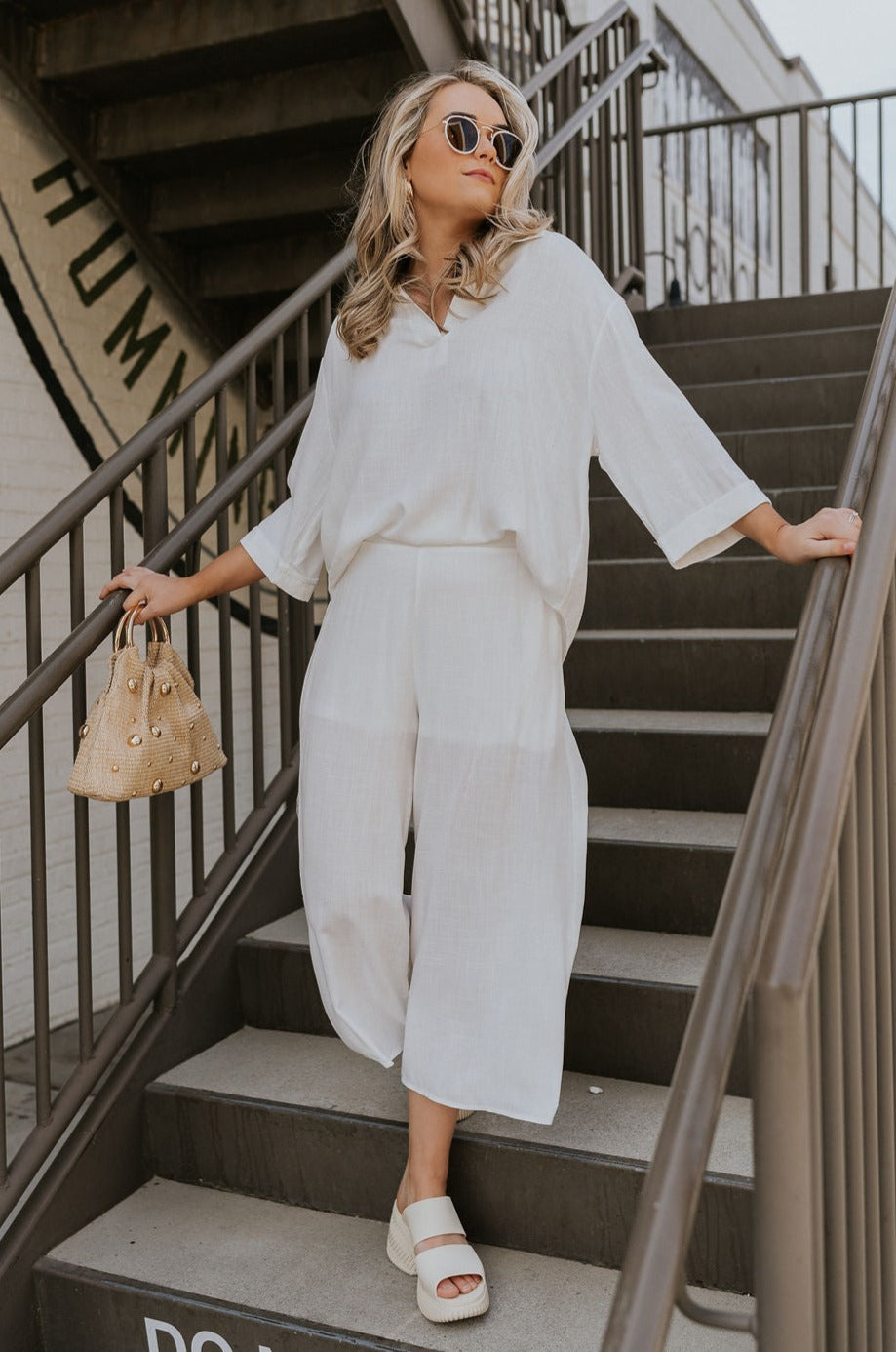 Full body view of female model wearing the ONA Streetworks Slide Heel Sandal in in Honey White & Sea Salt which features Cream Leather Lightweight Upper, Two Thick Straps, Slide-On Style, Traction Rubber Sole and 3" Heel, 1 1/14" Platform
