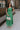Full body view of female model wearing the Selah Green Smocked Midi Dress which features Green Lightweight Fabric, Ruffle Tiered Body, Green Lining, Midi Length, Smocked Upper, Square Neckline and Thick Straps