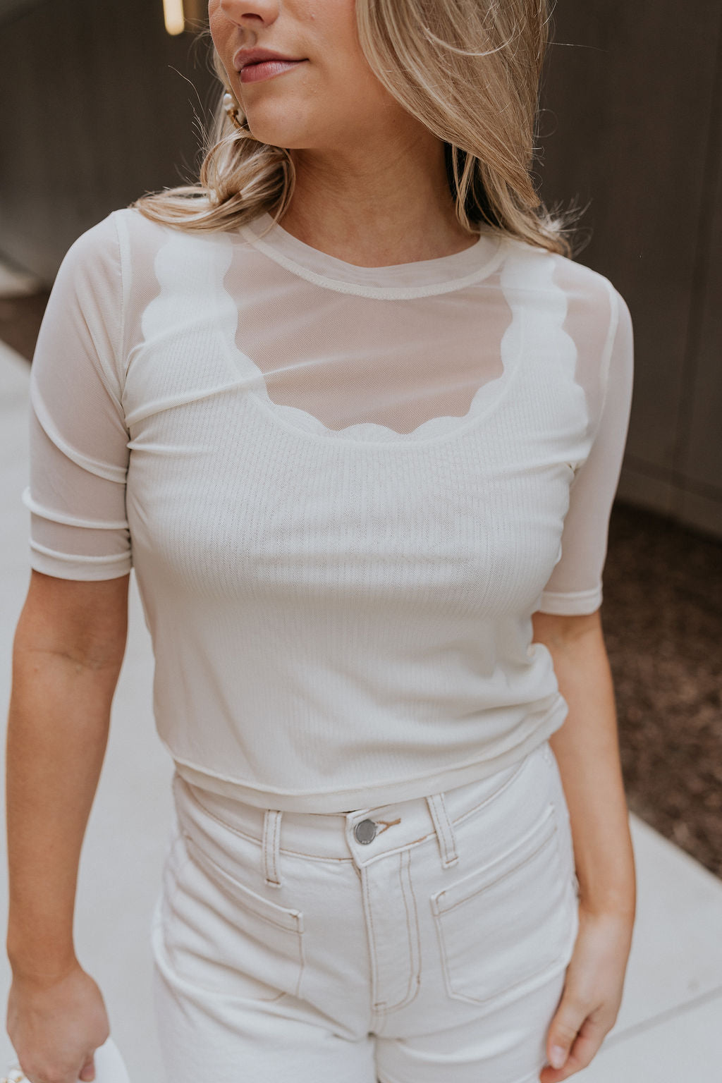 Close up  view of female model wearing the Lola Cream Sheer Short Sleeve Top which features Cream Sheer Fabric, Round Neckline, Cropped Waist and Short Sleeves