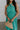 Close up view of female model wearing the Vera Halter Cross Neckline Midi Dress in Green which features Lightweight Fabric, Lining, Midi Length, Side Ties Waistband, Halter Cross Neckline, Adjustable Straps and Sleeveless.