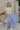 Full body view of female model wearing the Alana Periwinkle Tiered Maxi Skirt which features Periwinkle Lightweight Fabric, Maxi Length, Periwinkle Thigh Length Lining, Tiered Body and Elastic Waistband with Drawstring Ties