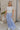 Full body view of female model wearing the Alana Periwinkle Tiered Maxi Skirt which features Periwinkle Lightweight Fabric, Maxi Length, Periwinkle Thigh Length Lining, Tiered Body and Elastic Waistband with Drawstring Ties