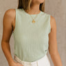 Front view of female model wearing the Kimber Mint Textured Tank that features mint green textured fabric, sleeveless body, and round neck. Tank is tucked into white shorts.