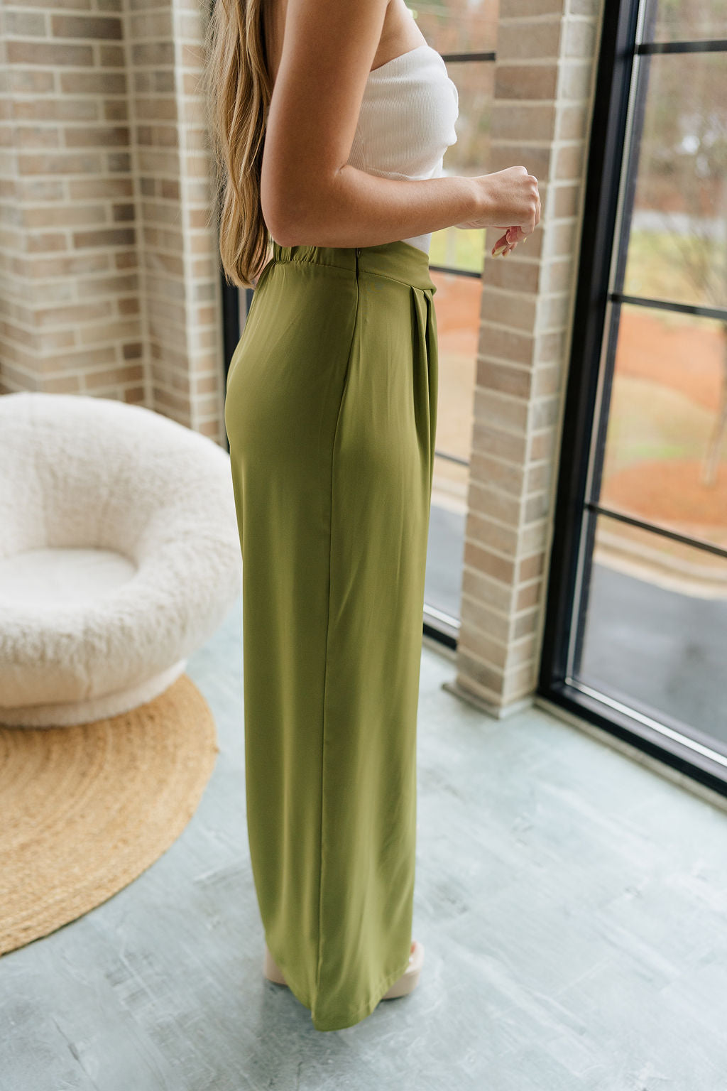 Side view of female model wearing the Rowan Olive Wide Leg Pants which features Olive Green Lightweight Fabric, Wide Pant Leg and Elastic V- Waistband
