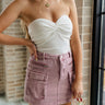 Front view of female model wearing the Jasmine Lavender Denim Cargo Skirt which features Washed Purple Denim Fabric, Two Front Zipper Pockets, Two Front Cargo Pockets, Two Back Pockets, Belt Loops and Mini Length