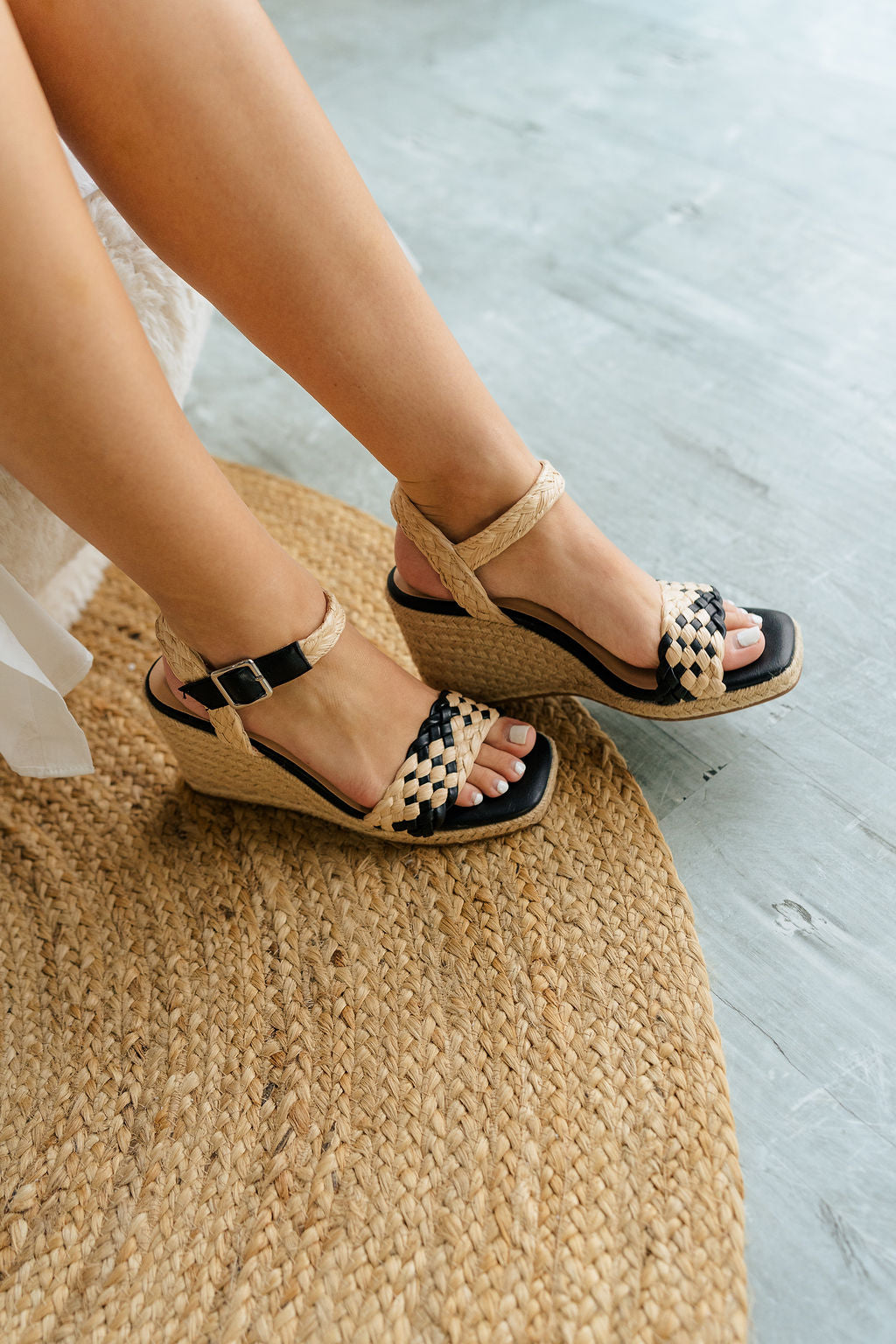 Front right angle view of the Getty Wedge Sandal in Black which features Raffia / synthetic leather upper, 3.75 in heel, 1 inch platform, adjustable buckle strap and esdpadrille sole.