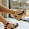 Front right angle view of the Getty Wedge Sandal in Black which features Raffia / synthetic leather upper, 3.75 in heel, 1 inch platform, adjustable buckle strap and esdpadrille sole.