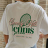 Back view of female model wearing the Beverly Hills Tennis Club Graphic Tee which features  White Cotton Fabric, Round Neckline , Short Sleeves, Beverly Hills Tennis Club in pink and green writing.