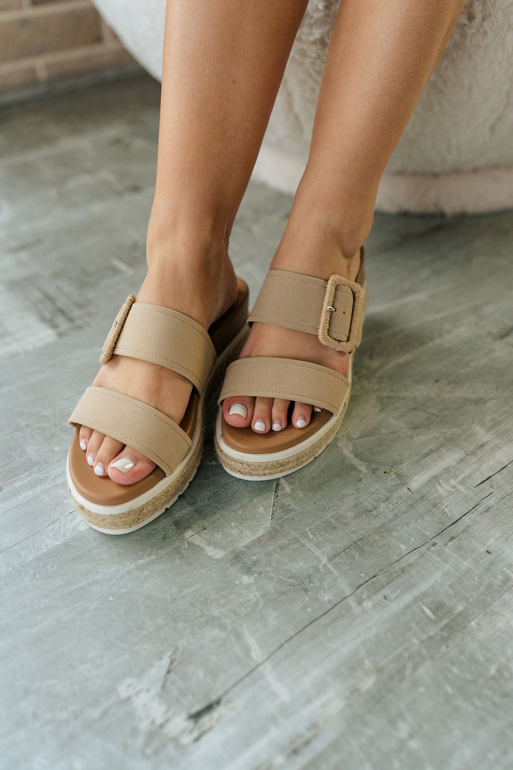 Front view of female model wearing the Kenzy Sandal which features Upper Leather Fabric, Two Straps with Adjustable Buckle Closure, Espadrille Details with White Sole and 2.3 inch heel.