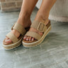 Side view of female model wearing the Kenzy Sandal which features Upper Leather Fabric, Two Straps with Adjustable Buckle Closure, Espadrille Details with White Sole and 2.3 inch heel.