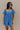 Front view of model wearing the Marissa Blue and White Floral Short Sleeve Romper which features Blue Lightweight Fabric, White Floral Design, Blue Lining, Square Neckline, Short Puff Sleeves and Smocked Back.