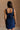 Back view of female model wearing the Stella Dark Denim Wash Sleeveless Mini Dress which features features Dark Denim Wash Fabric, Front Zip-Up Closure, Square Neckline and Sleeveless.