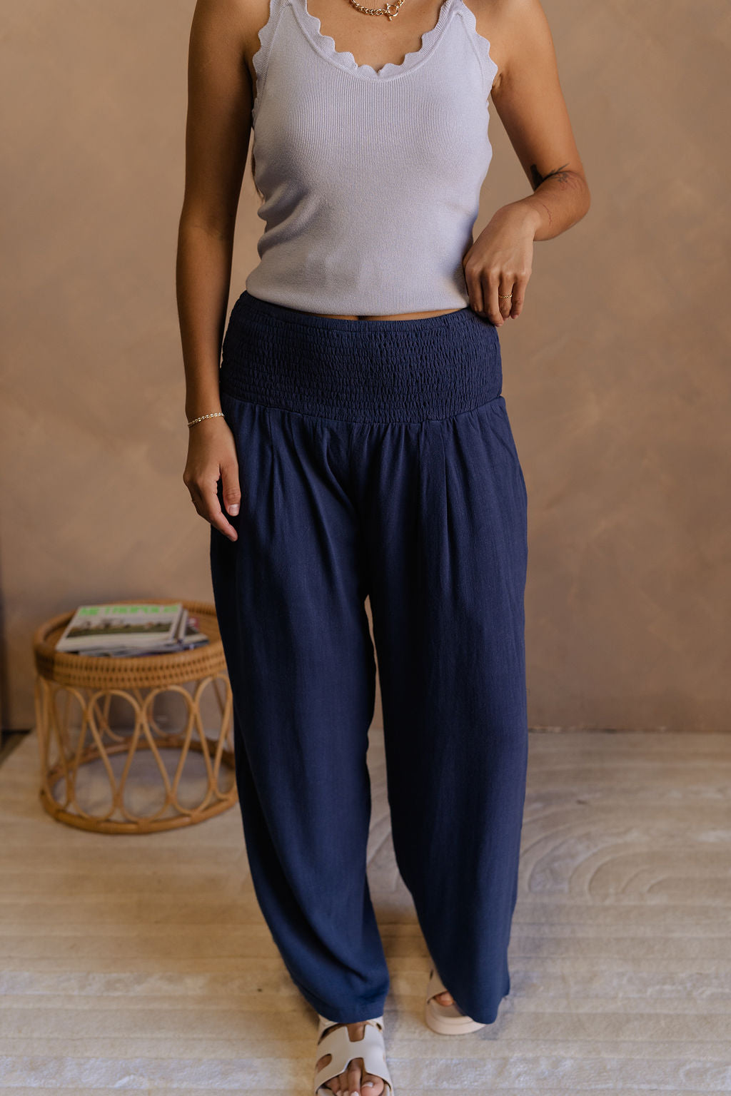 Front view of female model wearing the Olivia Navy Blue Smocked Pants which features Navy Knit Fabric, Wide Pant Legs, Navy Lining and Smocked Waistband