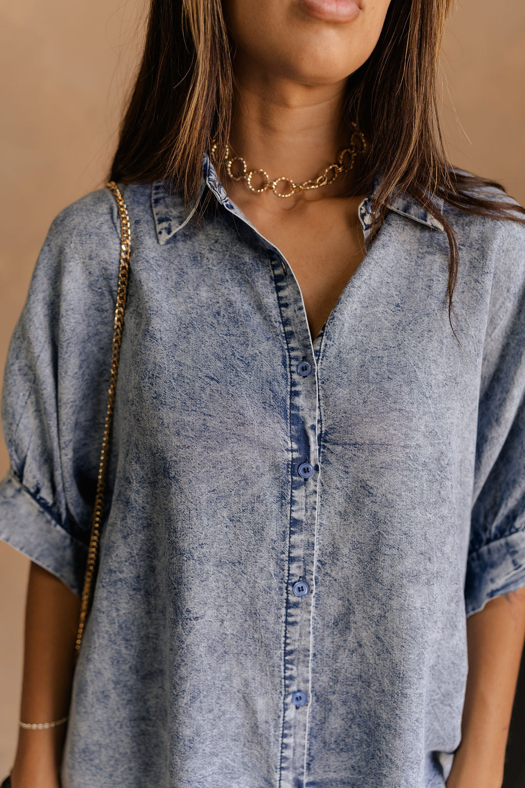 Close up view of female model wearing the Emma Button-Up Short Sleeve Mini Dress in Washed Denim which features Tencel Fabric, Mini Length, Front Button-Up Closure, Collared Neckline and Short Puff Sleeves.