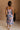 Full body back view of female model wearing the Madison Blue and Rose Pink Midi Dress which features Blue and Pink Floral Design, Midi Length, Sweetheart Neckline and Adjustable Straps.