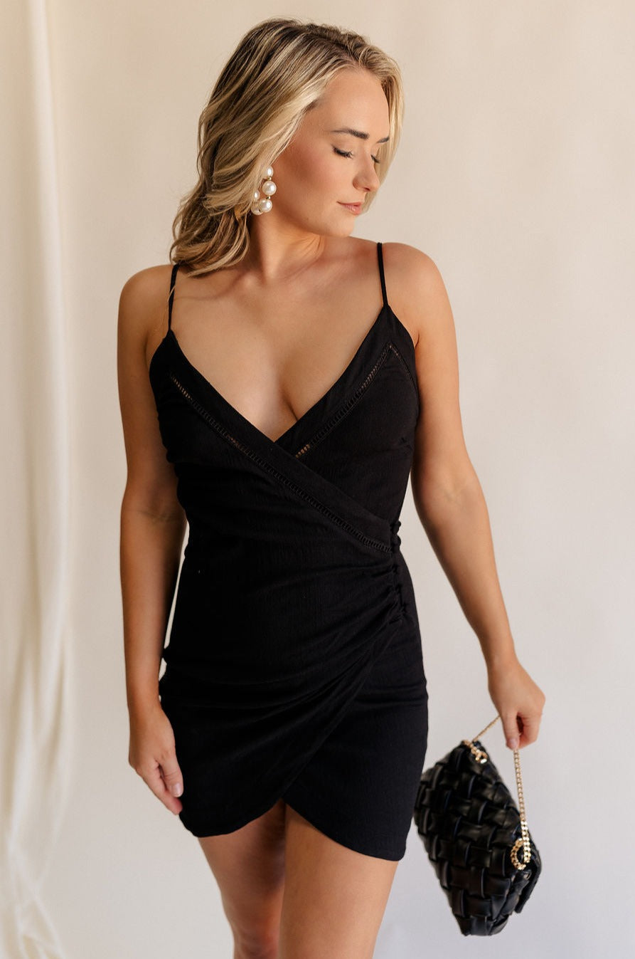 Front view of female model wearing the Sophia Black Plunge Neckline Mini Dress which features Black Lightweight Fabric, Mini Length, Side Ruched Detail with Covered Buttons Closure, Scoop Neckline, Adjustable Straps and Sleeveless