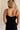 Back view of female model wearing the Sophia Black Plunge Neckline Mini Dress which features Black Lightweight Fabric, Mini Length, Side Ruched Detail with Covered Buttons Closure, Scoop Neckline, Adjustable Straps and Sleeveless