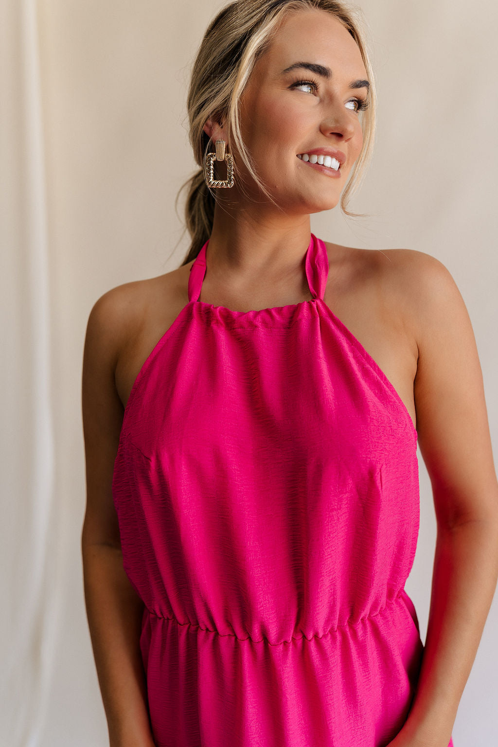Close up front view of female model wearing the Luna Halter Tie Tiered Maxi Dress in Pink which features Lightweight Fabric, Tiered Body, Maxi Length, Thigh Length Lining, Halter Neckline with Tie and Open Back