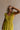 Upper body front view of female model wearing the Kristina Chartreuse Smocked Sleeveless Midi Dress that has chartreuse fabric with a smocked upper, ruffle straps, and a midi length hem.